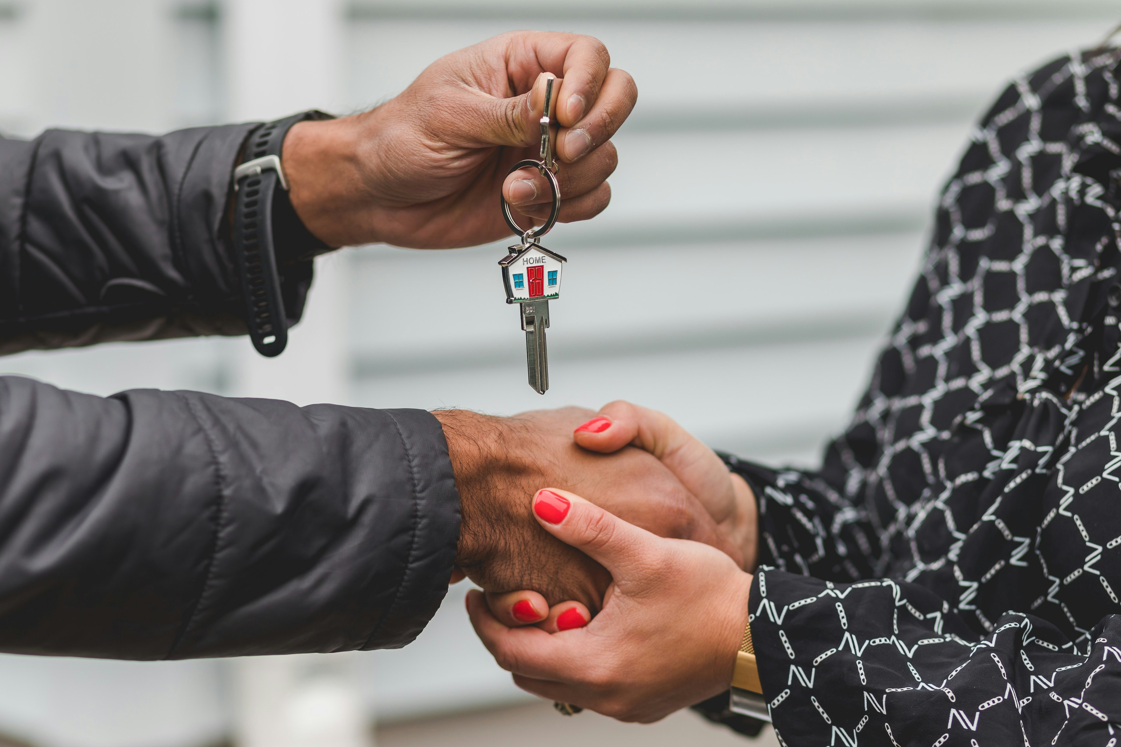 Mortgage professional handing keys to a first time homebuyer